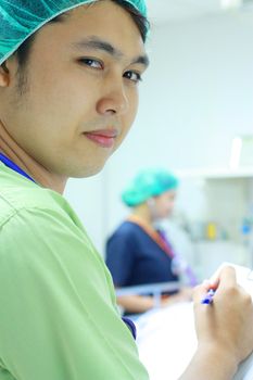 male asian nurse holding patients record
