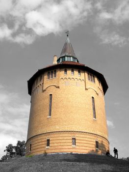 portrait of watertower on green hill in summertime