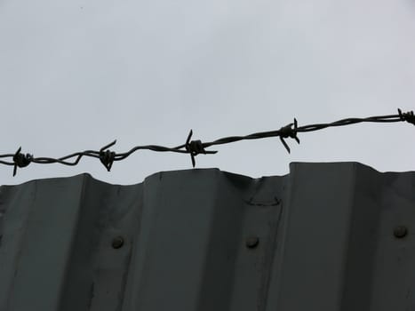 portrait of barbed wire fence and wall 