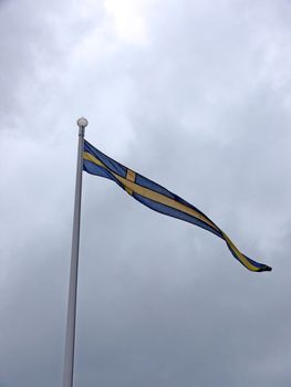 portrait of Swedish flag in cloudy sky