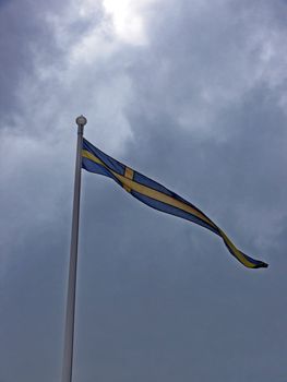 portrait of Swedish flag in cloudy sky