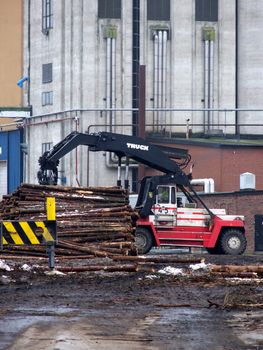 portrait of truck loading timber to a boat