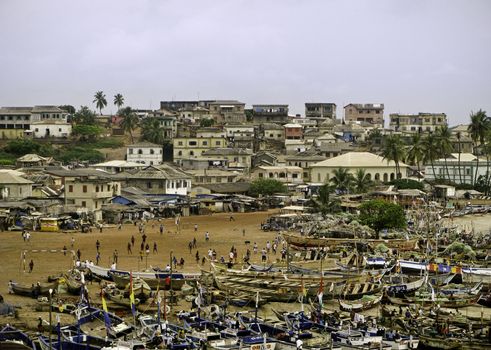 Very crowded beach with a market and numerous fishing boats in Accra in Ghana