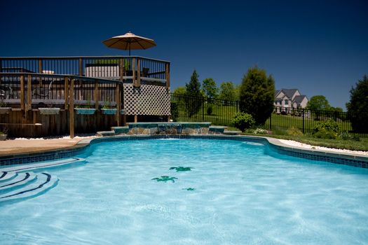 View of a backyard swimming pool with a deck taken from the water level