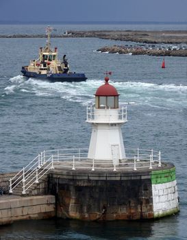 portrait of lighthouse and boat in background