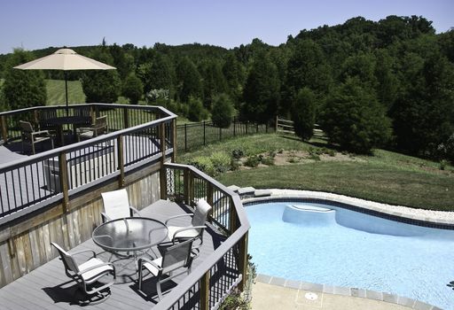 Backyard Pool in summer with surrounding multi-level deck