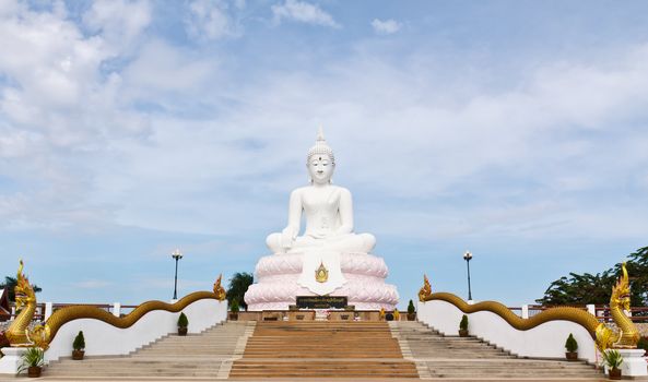 White Buddha statue with blue sky.