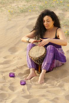 Woman outdoors enjoying the sunshine and playing her djembe