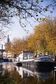 Ship in harbor on sunny october morning with church tower in background