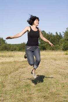 portrait of happy woman jump in countryside 