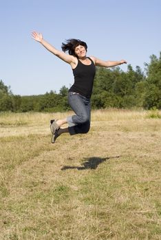 portrait of happy woman jump in countryside 