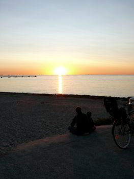 portrait of midnight sun infront man and child