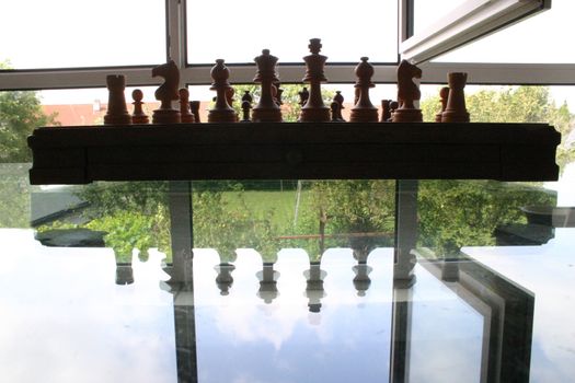 Chessboard on a glass table with open window