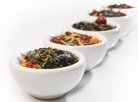 Various bowls of premiun tea leaves blends, over white