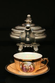 Silver teapot and an antique chinese cup of tea. More in gallery