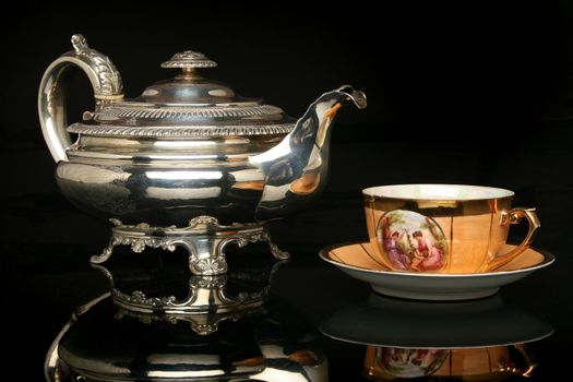 Silver teapot and an antique chinese cup of tea. More in gallery