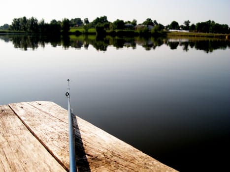 rod on the wooden bridge at the lake