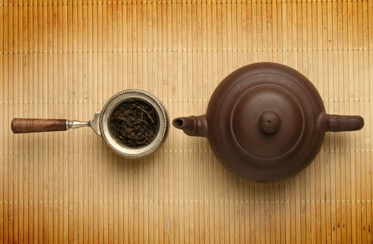 Antique teapot and a scoop with tea leaves 