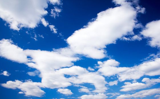 White cumulus clouds and a blue sky. 