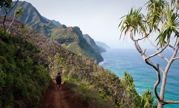 Kalalau trail path on Na Pali coast with three female hikers