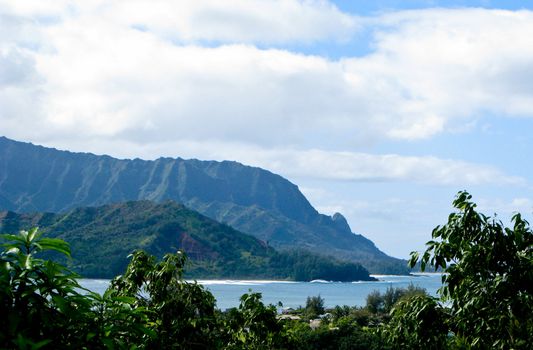 Na Pali coastline off the north coast of Hawaii framed by verdant trees
