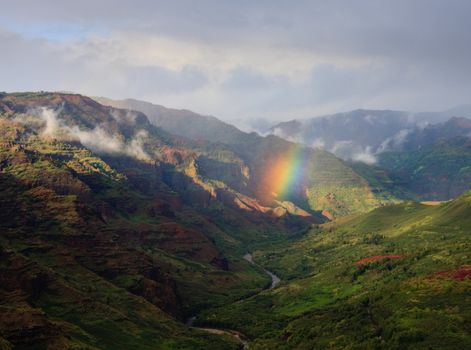 Rainbow in the center of the river valley of Waimea Canyon on Kauai