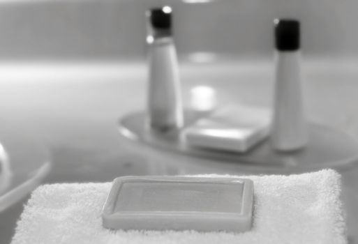 soap on a towel in black and white with other personal care items as a blur