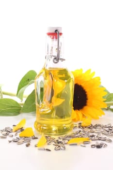 Sunflower oil with sunflowers and sunflower seeds on a white background