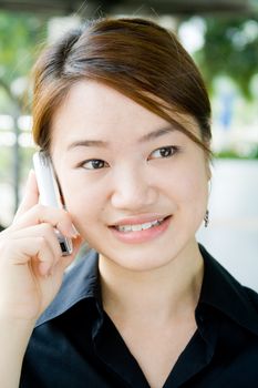 Beautiful and pretty asian business woman posing with mobile phone