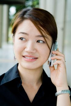 Beautiful and pretty asian business woman posing with mobile phone