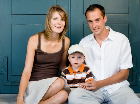 Happy perfect young family with dad, mom and son outdoors having fun