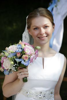Portrait of the beautiful bride with a bouquet