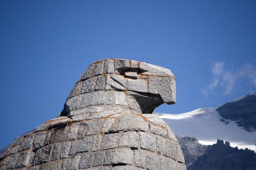 A statue of an eagle, head details, mountains in background