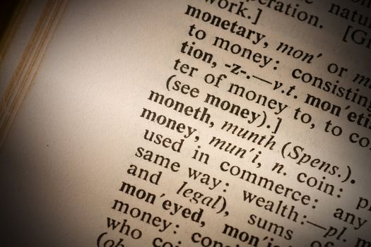 Closeup of the word money with a spot light on the text