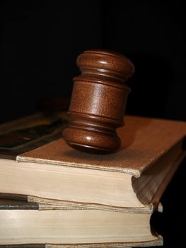 Gavel on old law books, dark tones