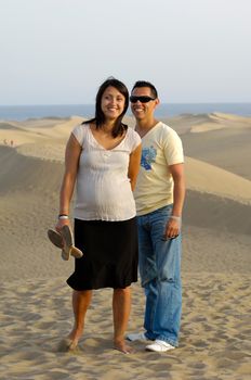 Happy couple on vacation. The woman is 4 month pregnant.