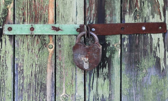 Old wooden doors locked with rusty padlock 