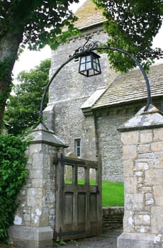 A rural medieval church entrance, gate and stone pillars, found in Dorset, UK.