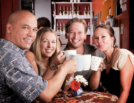 Friends in a coffee house toasting with their cups