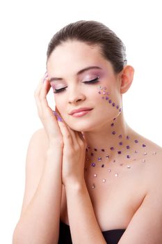 Headshot of a beautiful Caucasian woman with purple makeup and rhinestones with eyes closed, isolated