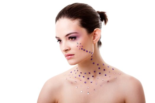 Headshot of a beautiful Caucasian woman with purple makeup and rhinestones and bare shoulders, isolated