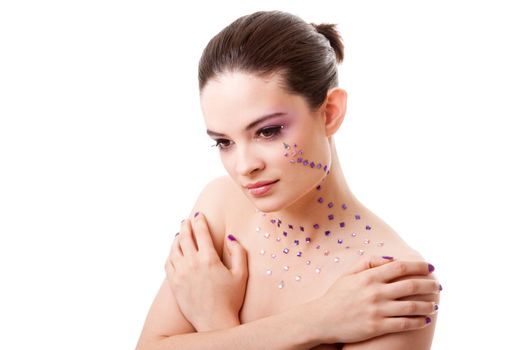 Headshot of a beautiful Caucasian woman with purple makeup and rhinestones, isolated