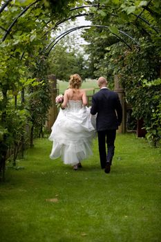 Bride and groom walking together in the garden