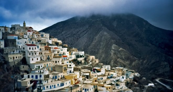 Greek village view with mountains and dramatic sky