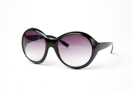 Female sun glasses in a black frame and lilac lenses on a white background close up
