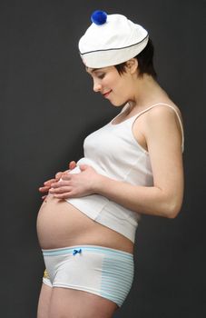 The pregnant woman looks at a stomach