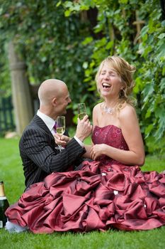 Beautiful newly wed couple having a good laugh in the garden