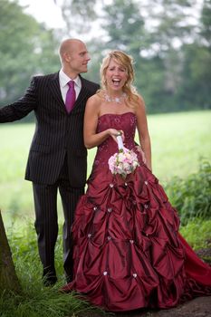 Beautiful bride and groom having a laugh outdoors while posing