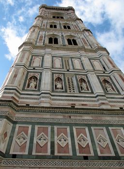 A view from the street level looking directly up the bell tower next to the Florence, Italy Duomo. The campanile (tower) was designed by the architect Giotto.