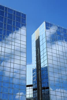 Complex of office buildings with mirror walls in which the sky is reflected
